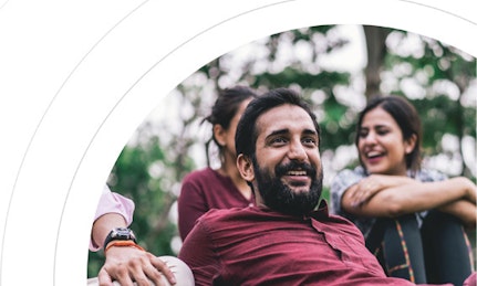 A diverse group of friends rest together on the grass