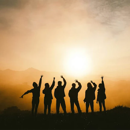 A group of friends wave at the sunrise