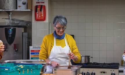 A person does volunteer work in a kitchen