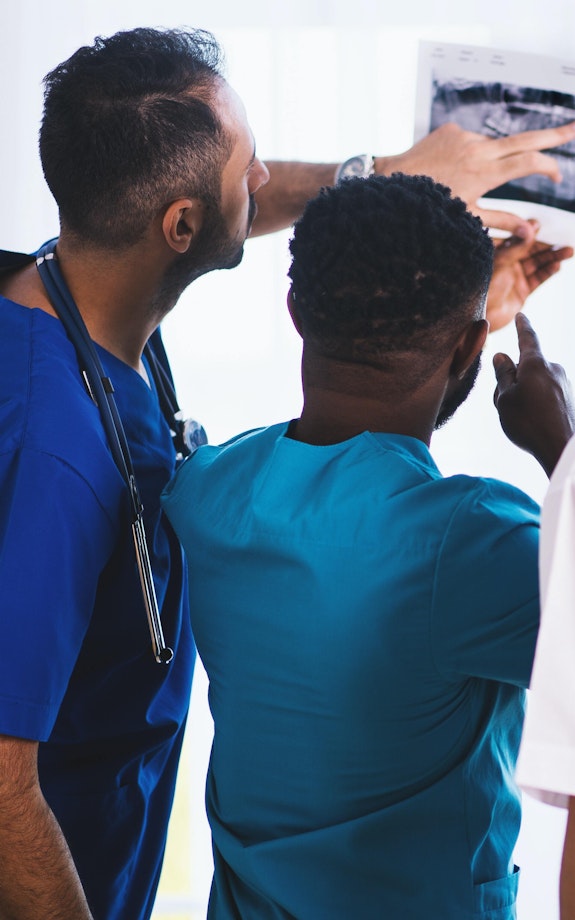 A team of medical professionals review the results of a scan