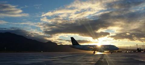 A plane parked at airport with sunrising behind it